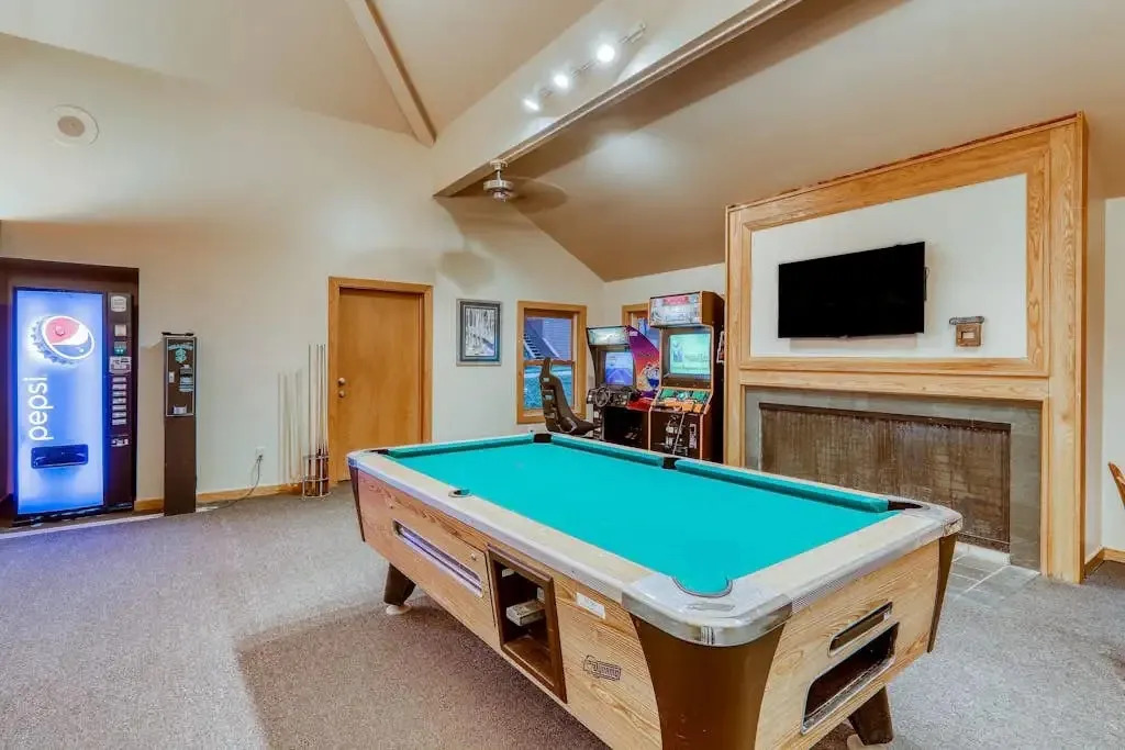 Game room with a pool table, arcade machines, and a vending machine