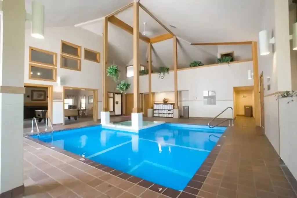 Indoor pool at the activity center with a vaulted ceiling and mezzanine level above